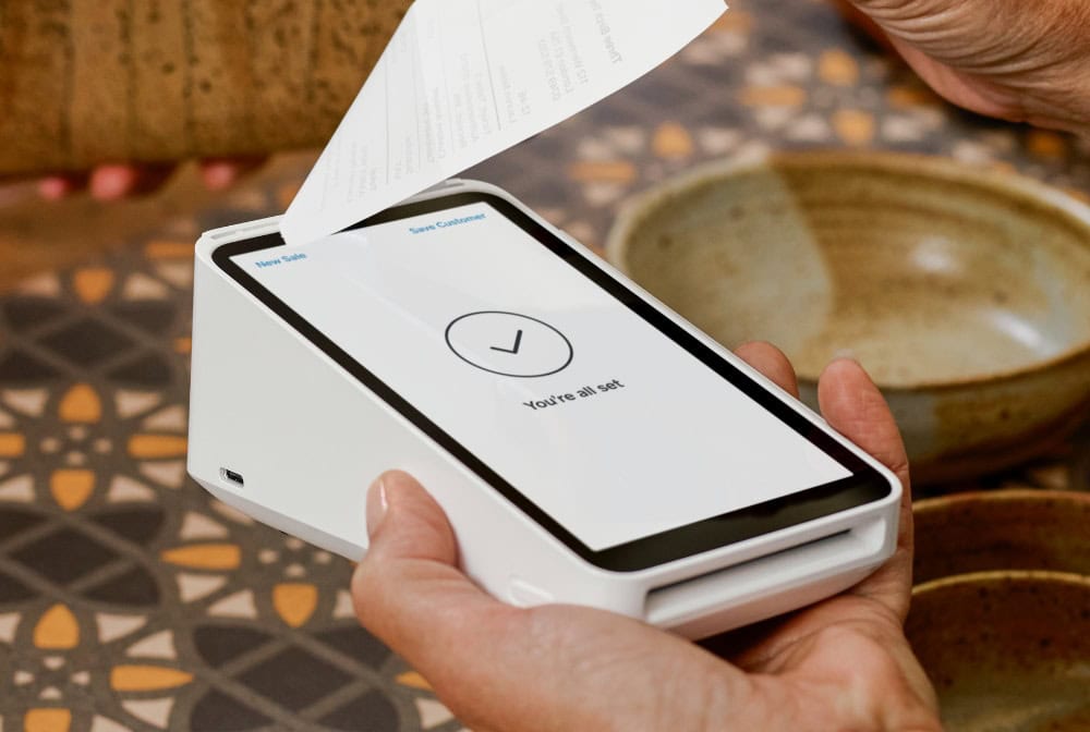 Image of a square terminal in a persons hand